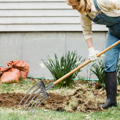 femme utilisant fourche jardinier pour désherber et ameublir le sol