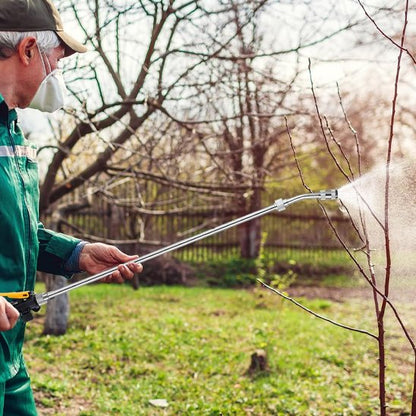 Lance pulverisateur utilisé par homme pour arroser jeunes arbres