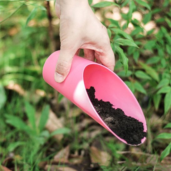 personne qui ajoute de la terre avec la petite pelle jardin