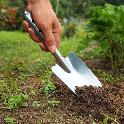 personne qui utilise la petite pelle de jardin 