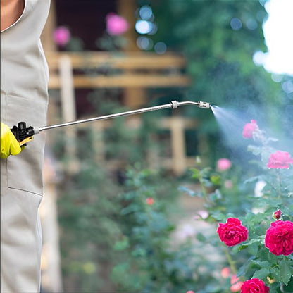 personne qui utilise une Lance pulverisateur pour arroser ses rosiers
