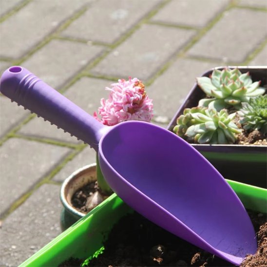 petite pelle jardin vue de proche et déposé près des fleurs